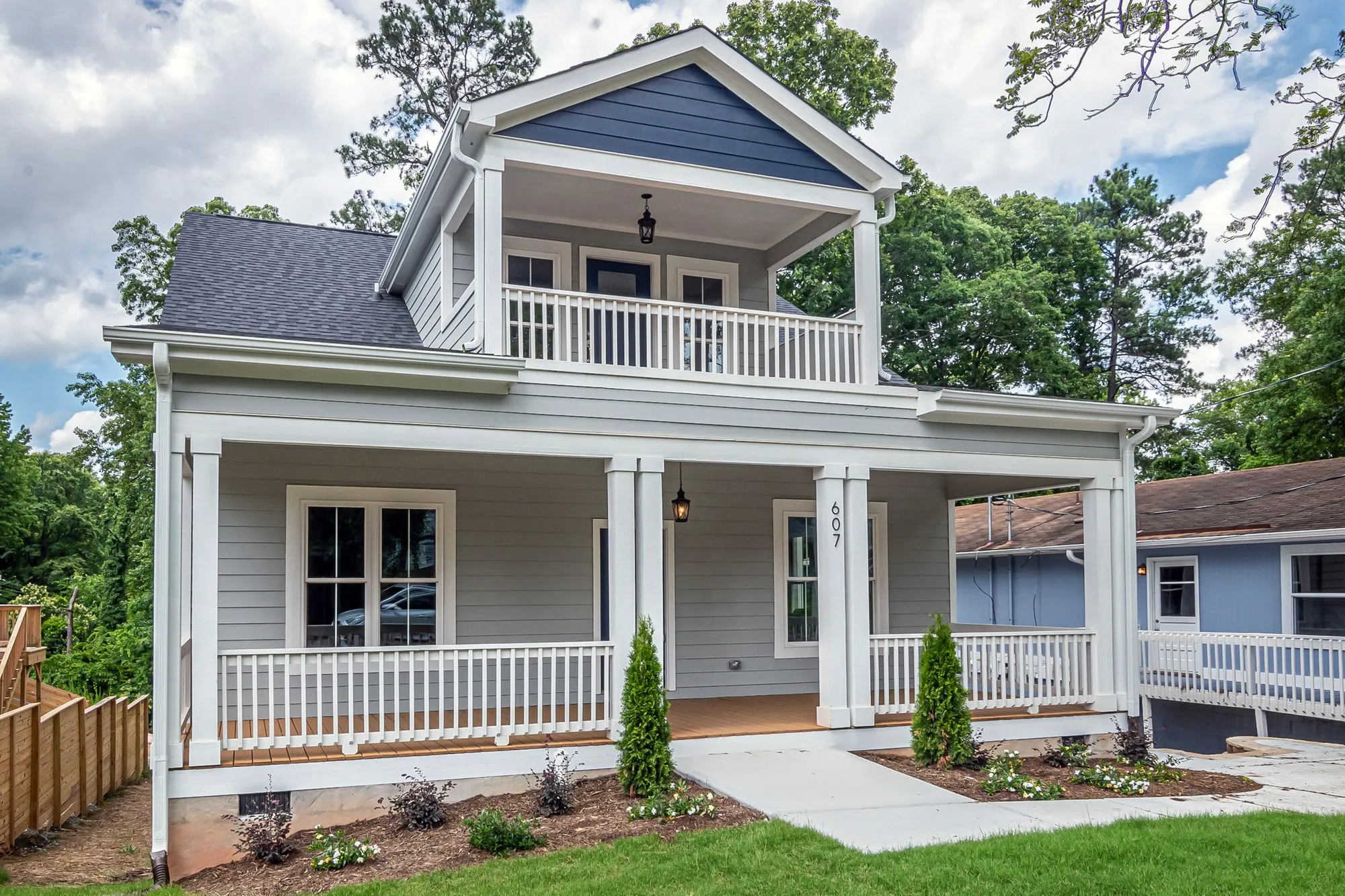 White two-story house with an upper balcony and a covered front porch